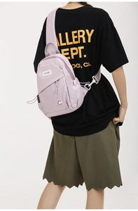 Detail of adjustable strap and spacious zipper pockets on a purple nylon crossbody chest bag