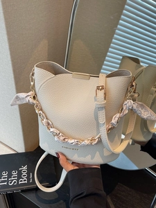 Sac seau beige en cuir avec poignée chaîne foulard en soie et lettrage doré