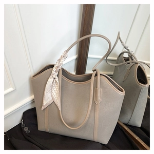 Detail of grey-brown lychee grain leather tote bag featuring a decorative silk scarf
