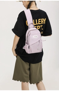 Detail view of light purple nylon chest bag showing water-resistant fabric and zippers