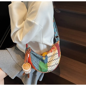 Dettaglio della borsa a mezzaluna patchwork bohémien con motivi floreali e ciondolo a tazza