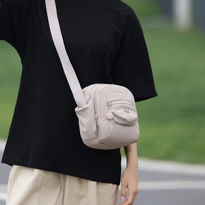 Détails du sac bandoulière en nylon résistant à l'eau montrant zips et texture