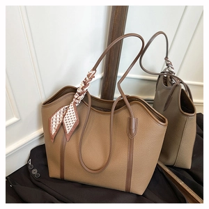 Detail of dark brown tote bag featuring lychee texture and stylish patterned silk scarf