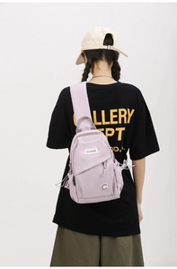 Detail of light purple nylon chest bag with wide shoulder strap shown on a model