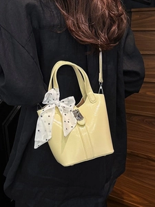 Moderna borsa a secchiello giallo chiaro con manico in seta e chiusura in argento