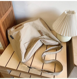 Detail of light beige waterproof oxford bag with wide shoulder strap and CHUANGMI tag