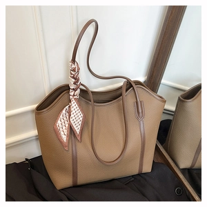 Detail of brown litchi pattern leather tote bag with a stylish geometric silk scarf