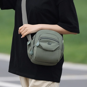 Détail de la sacoche bandoulière en nylon vert avec fermeture éclair et sangle