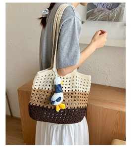 Close-up of three-tone knitted tote bag showing cotton rope crochet detail and bird charm