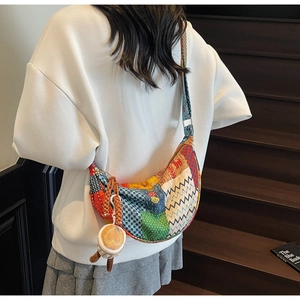 Dettaglio borsa tote a mezzaluna in tela patchwork con tracolla e ciondolo