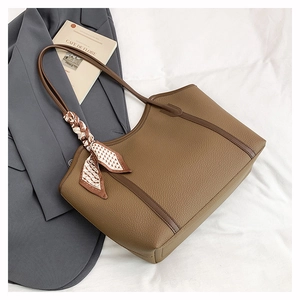 Detail view of brown pebbled leather tote bag with stylish patterned silk scarf accessory