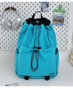Detail of light blue water-resistant drawstring backpack featuring TUTIE logo