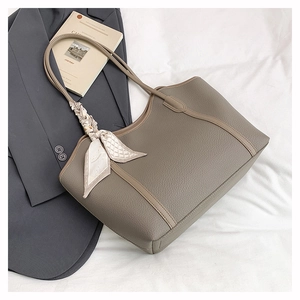 Detail of khakhi tote bag in lychee leather texture with decorative geometric silk scarf
