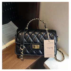 Detailed view of black quilted leather shoulder bag with gold chain and twist-lock buckle