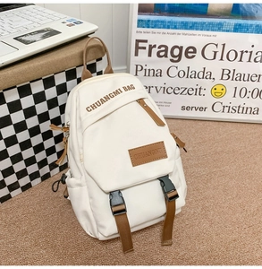 Detail of cream canvas backpack with brown nylon straps and durable plastic buckles
