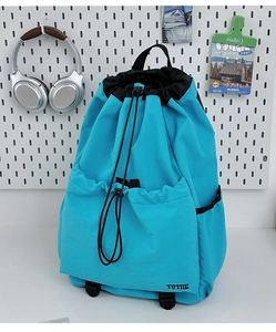 Close-up of sky blue drawstring backpack featuring front pocket and TUTIE brand logo