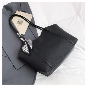 Detail of black pebbled leather tote bag with stylish geometric pattern scarf detail