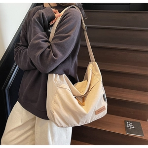 Détail d'un grand sac fourre-tout beige clair avec bandoulière réglable et style décontracté