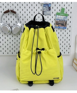 Detail of bright yellow waterproof drawstring backpack with durable nylon texture and side pocket