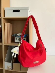 Red large capacity nylon crescent crossbody bag with shoulder strap and cartoon pendant