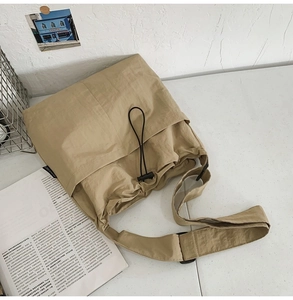 Top view of a khaki large-capacity nylon bucket bag with drawstring and pleat detail