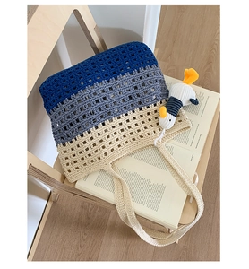 Detailed knit texture of a three-tone gradient woven tote bag with a cute duck charm