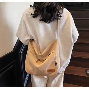Détail d'un sac cabas en toile kaki avec tirette de zip en cuir et poche latérale pratique