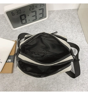 Macro view of inner multi-compartment structure and durable zipper for this light gray bag