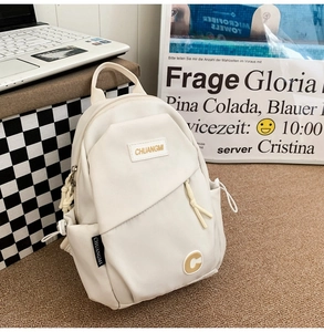 Close-up of a cream crossbody chest bag with brand patch and side drawstring pocket