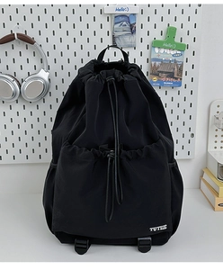 Close-up of lightweight black drawstring backpack with front pocket on storage board