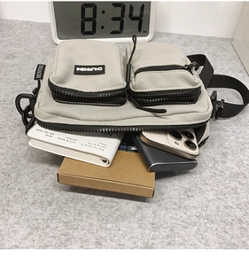 Detail view of the multi-pocket nylon crossbody bag showing large internal storage capacity