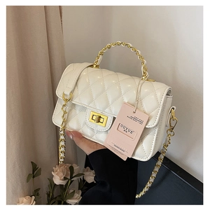 Detailed view of white quilted leather texture and golden twist lock on chain bag