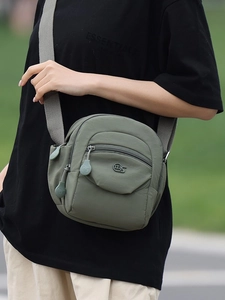 Sac bandoulière en nylon gris-vert avec poches zippées et sangle réglable