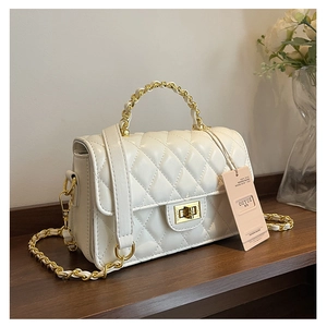 Macro shot of white quilted leather texture with gold rectangular twist lock closure