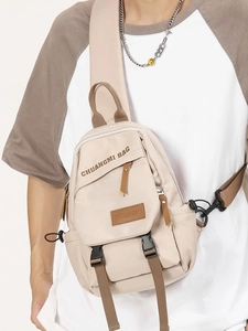 Beige nylon crossbody sling bag with multiple zip pockets and brown adjustable strap