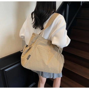Detailed back view of a khaki canvas tote bag with side drawstring and wide strap