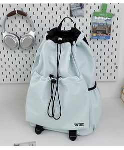 Close-up of lightweight water-resistant blue drawstring backpack with black TUTIE embroidery