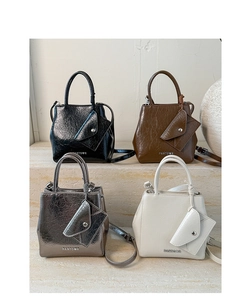 Detailed view of textured patent leather handbags in four colors with hanging coin purses