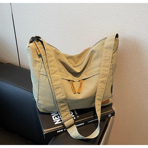 Détail du sac cabas en toile vert olive avec deux fermetures éclair et bandoulière