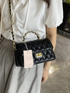 Elegant black quilted leather crossbody bag with gold chain strap and turn-lock closure