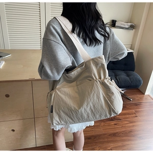 Detailed view of spacious khaki canvas tote bag worn by a model in a minimal office setting