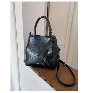 Detail of black wrinkled patent leather handbag with mini envelope pouch and Pantoor logo