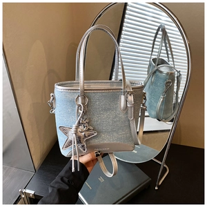 Détail du cabas en denim bleu clair avec strass et breloque étoile argentée
