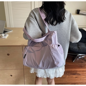 Detail of light purple canvas tote with drawstring ruching and brand label design
