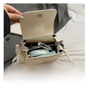 Vue intérieure du petit sac bandoulière blanc cassé montrant le rangement du téléphone