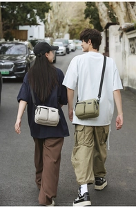 Outdoor canvas crossbody bags in white and olive green with dual zipper pockets