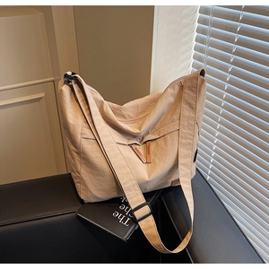 Détail du sac cabas beige en toile avec poche zippée et bandoulière large confortable