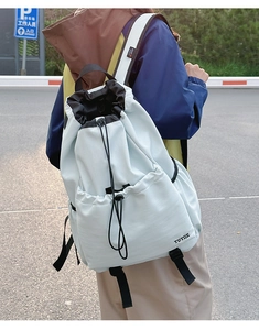 Outdoor shot of mint green drawstring backpack showing durable waterproof fabric texture
