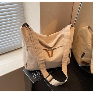 Détail du sac fourre-tout en nylon beige avec tirette de zip en cuir marron et sangle