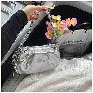 Sac nuage argenté métallisé avec design plissé et détail d'étoile à l'intérieur d'une voiture